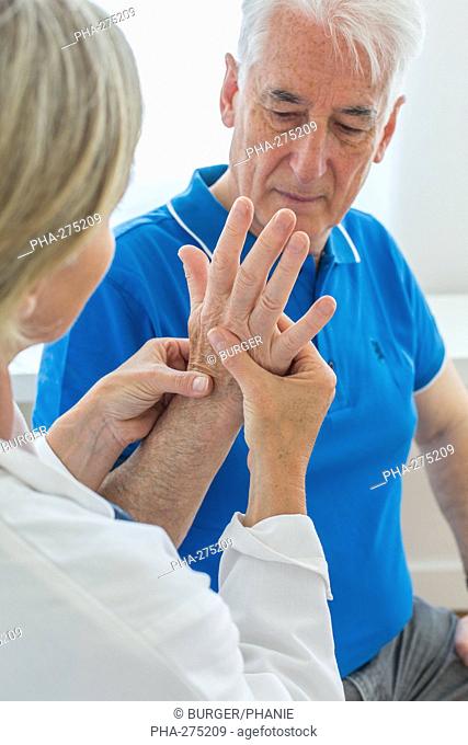 Doctor examining the hand of elderly man
