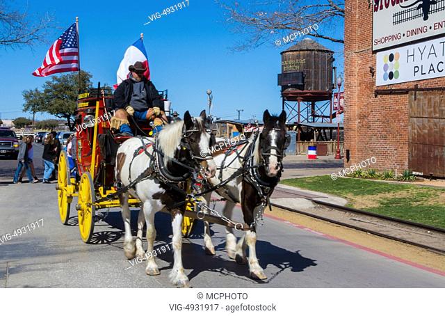 Ft Worth Texas Main Street red stagecoach for tourists to ride near The Stockyard famous for the Longhorn herds that come thru town with Cowboys 2 - 11/03/2028