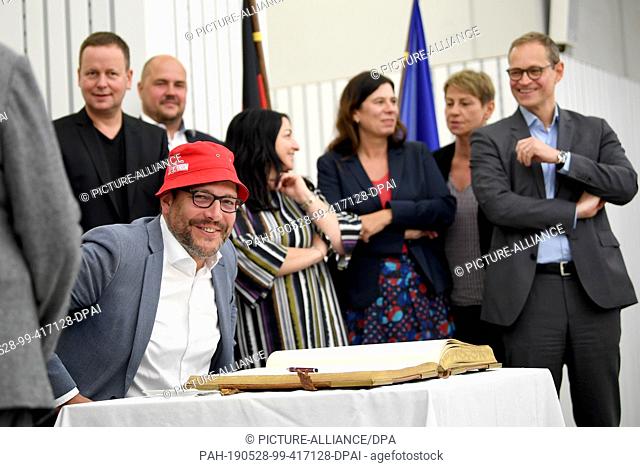 28 May 2019, Berlin: Dirk Behrendt (Bündnis 90/Die Grünen, Vorne), Senator of Justice of the State of Berlin, is in the Golden Book after the session of the...