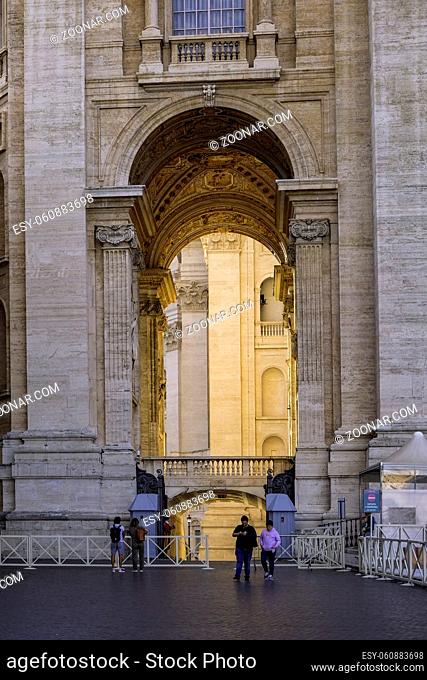 Tourists Walking in front of Arco delle Campane - Saint Peter Basilica against a Blue Sky - Vatican City