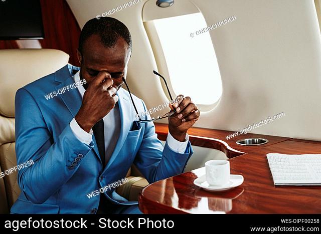 Worried male entrepreneur sitting in private jet