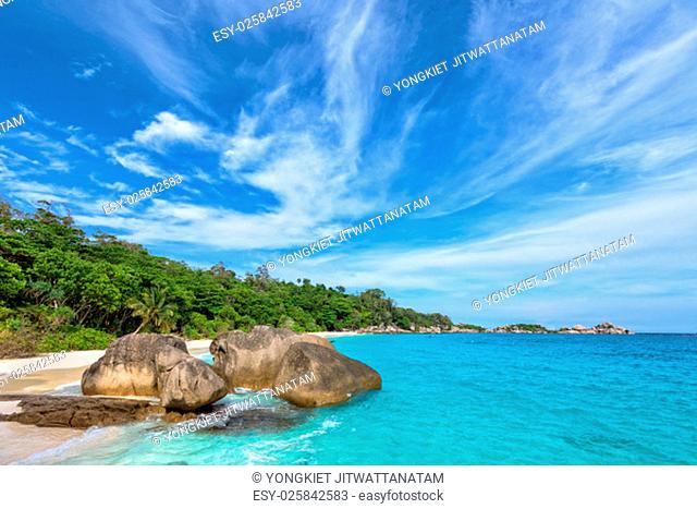 Beautiful landscape of blue sky sea sand and white waves on beach near the rocks during summer at Koh Miang island in Mu Ko Similan National Park