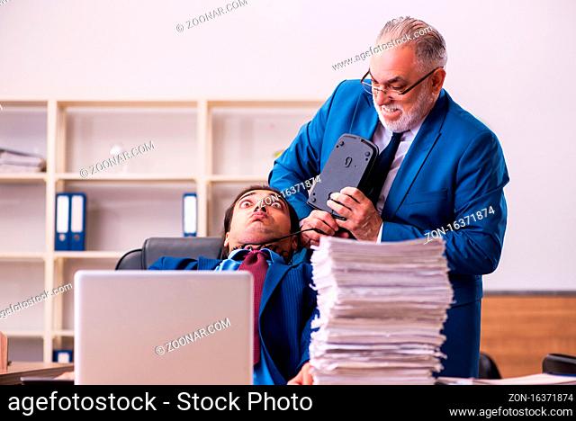Old boss and his young male assistant in bullying concept