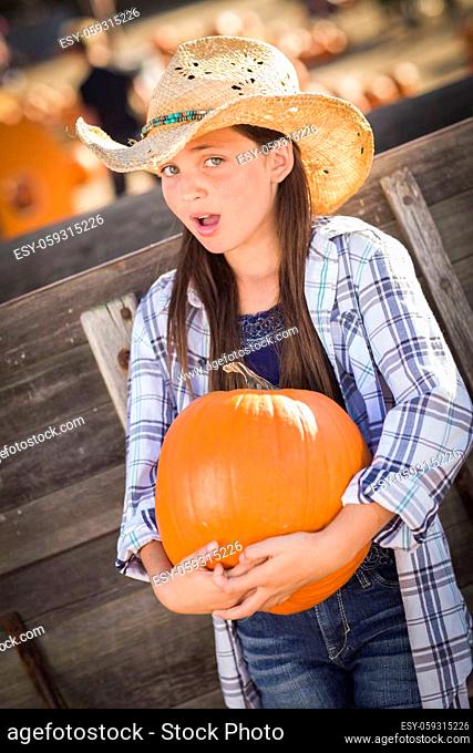 Preteen Girl Wearing Cowboy Hat Portrait at the Pumpkin Patch in a Rustic Setting