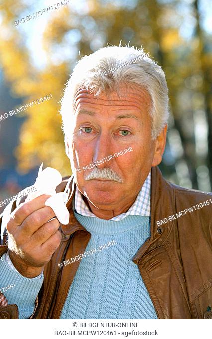 older man in autumn having a cold