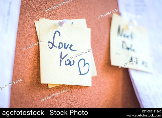 Close up of pinned note ?Love you? on cork board