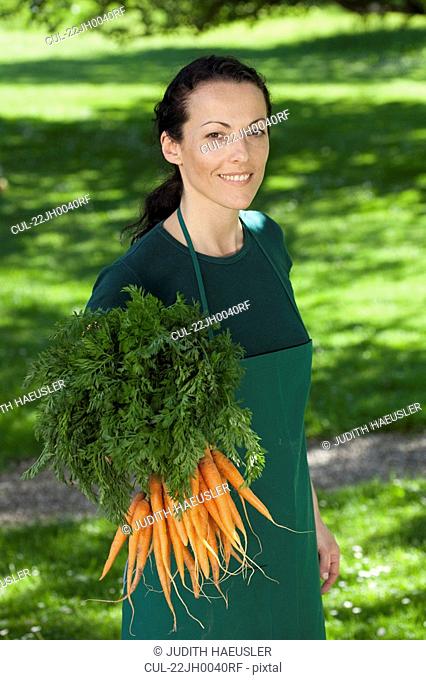 Female gardener with bunch of carrots