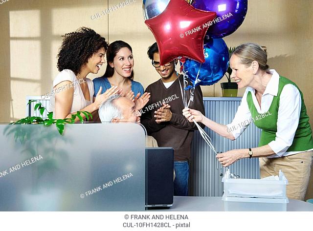 Group of people celebrating co-worker