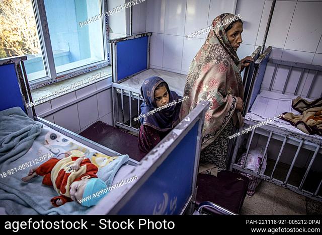 14 November 2022, Afghanistan, Kabul: An Afghan mother and her daughter are seen next to an infant in a ward for severe malnutrition in a hospital in Kabul
