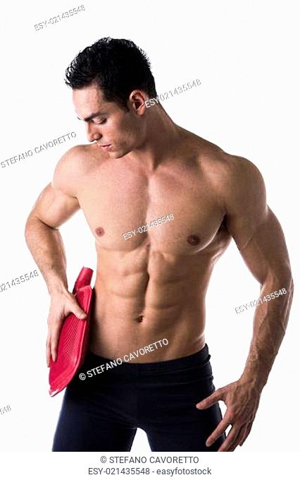 Handsome young man with hip pain, holding hot water bottle