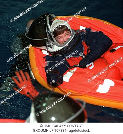 Astronaut Wendy B. Lawrence, STS-91 mission specialist, enjoys a light moment with a crew mate while purging excess water from her life raft during an emergency...