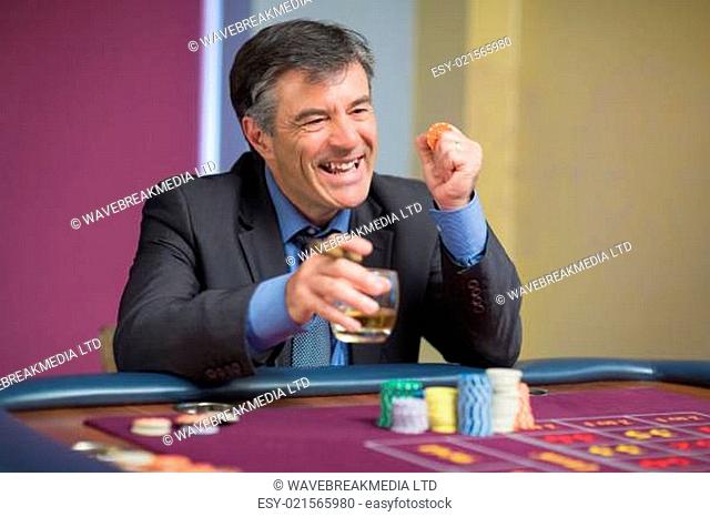 Man winning at roulette table in casino