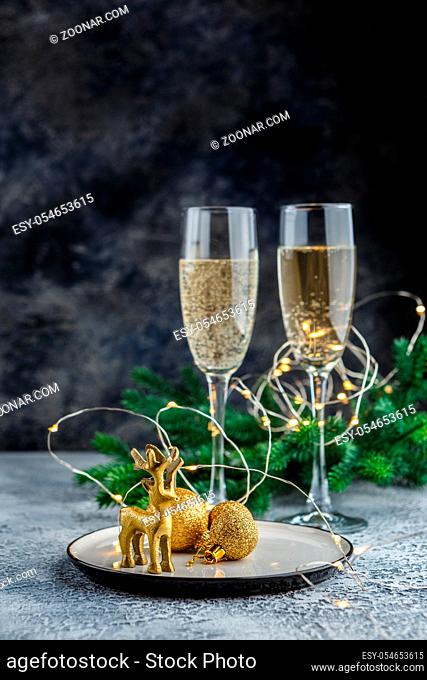 Christmas and New Year celebration with champagne. New Year holiday decorated table. Two Champagne Glasses. Holiday Decorations. Copy space