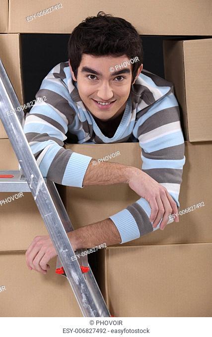 Lad surrounded by cardboard boxes