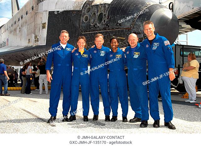 The STS-121 crew poses in front of the Space Shuttle Discovery near the landing facility at Kennedy Space Center following NASA's second Return to Flight...