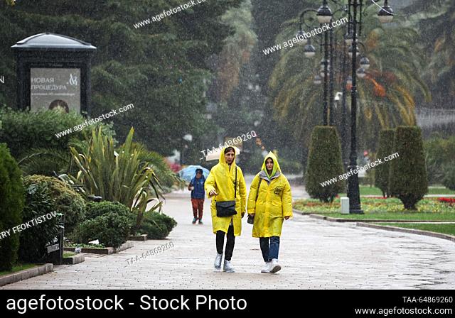 RUSSIA, SOCHI - NOVEMBER 16, 2023: Women walk in yellow raincoats during the ran in a street. Dmitry Feoktistov/TASS