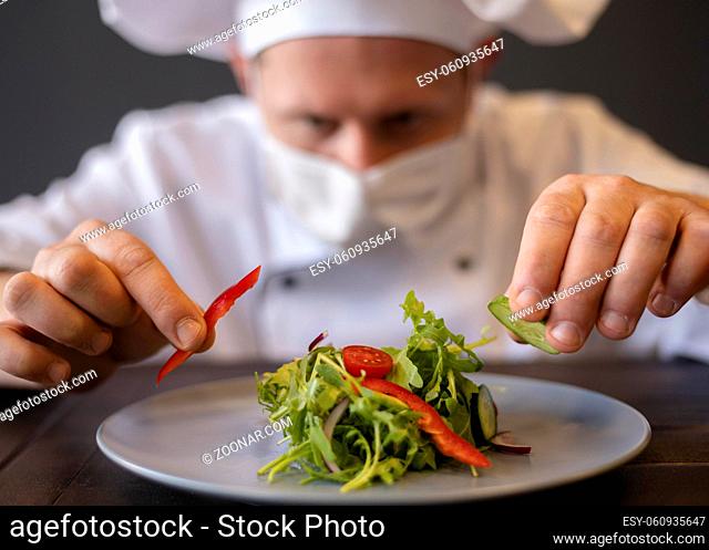 close up chef with mask preparing dish