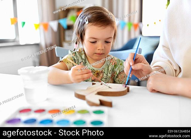 mother with child coloring easter bunny at home
