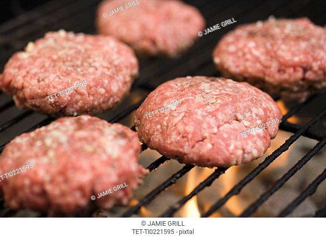 Hamburger patties cooking on grill