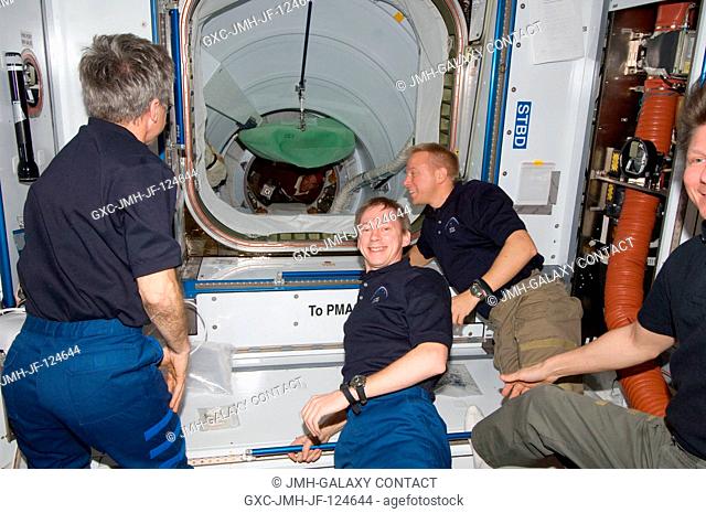 Expedition 20 crew members are pictured in the Harmony node of the International Space Station as Space Shuttle Discovery's crew ingress through the station's...