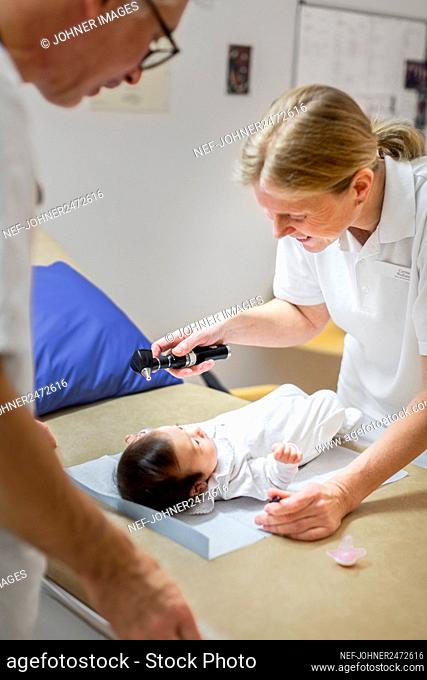 Female doctor examining baby