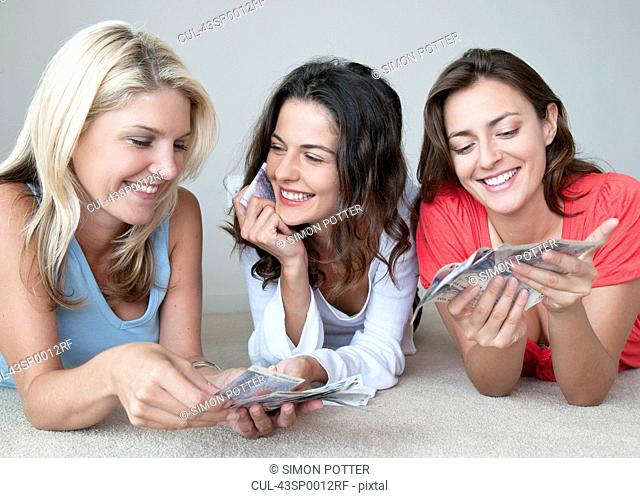Smiling women counting money together