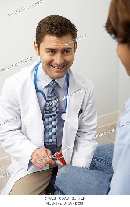 Doctor examining young patient with reflex hammer