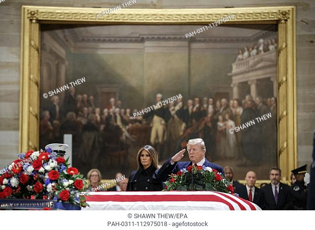 US President Donald J. Trump, with First Lady Melania Trump, salutes the casket containing the body of former US President George H.W