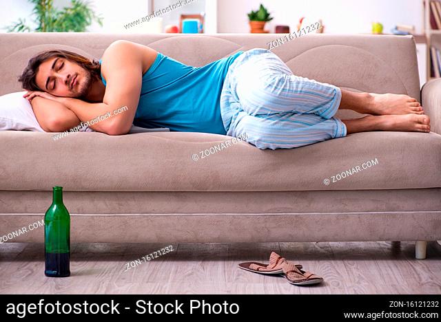 Young man waking up after party at home