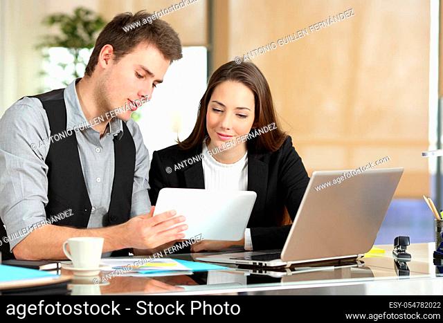 Employee helping coworker showing tablet