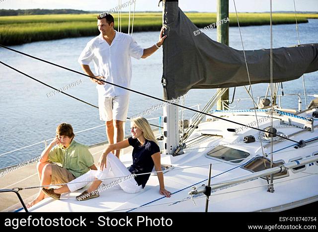 Father and teenage children on sailboat