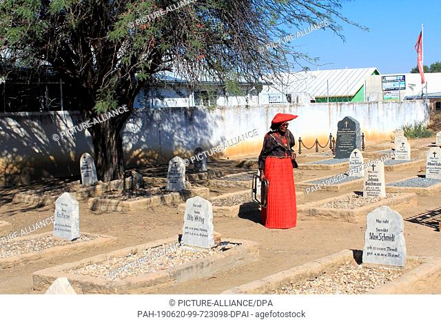 04 June 2019, Namibia, Okahandja: A woman in the costume of the Herero tribe walks through a German military cemetery in Okahandja