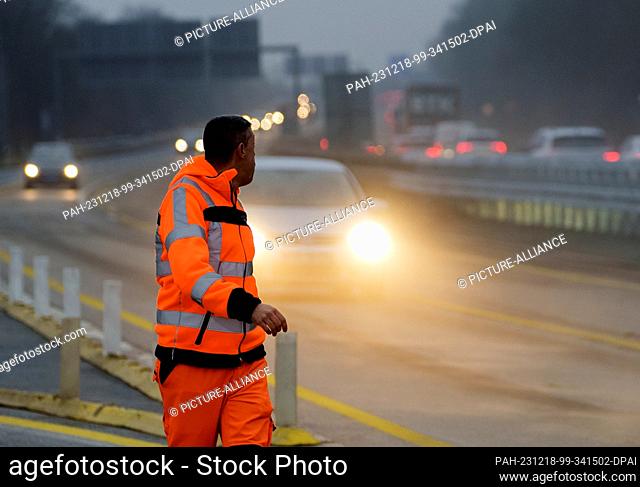 18 December 2023, Hesse, Wiesbaden: A worker checks on the traffic immediately after the southern section of the Salzbachtal bridge was opened to traffic