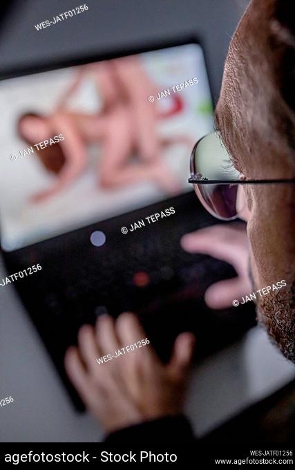 Man watching pornography on laptop at home