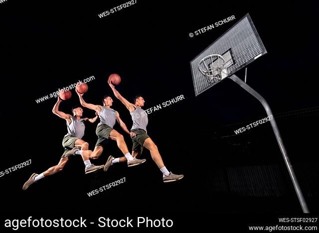 Multiple image of young man jumping while playing basketball at night