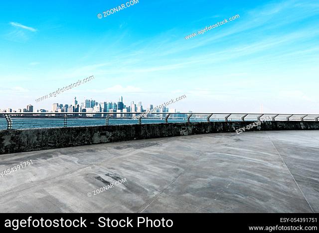 empty concrete road and cityscape of hangzhou in blue sky