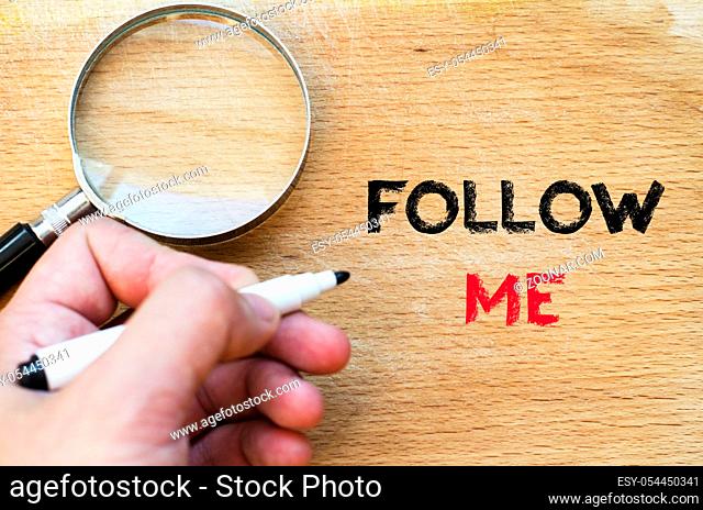 Human hand over wooden background and follow me text concept