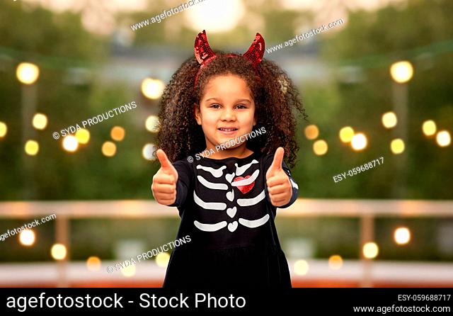 girl in black dress and devil's horns on halloween