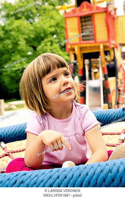 Little girl on playground in nest swing