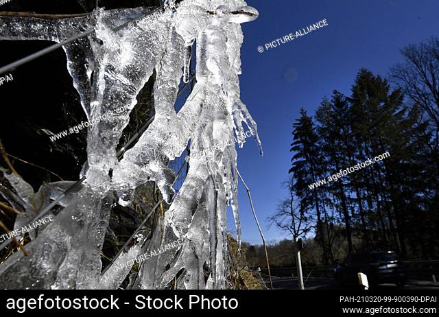 20 March 2021, North Rhine-Westphalia, Monschau: Ice hangs from a wire netting used to secure a federal highway. During the night