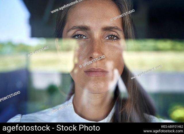 Serious woman staring through glass