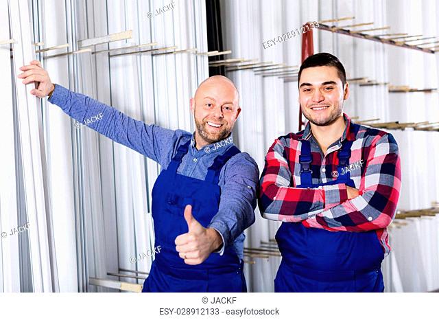 Two cheerful workmen enjoying of production plan overfulfilment at factory