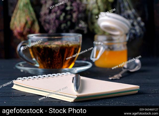 Recipe of healing herbal tea with open notebook