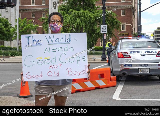 Peaceful protester holds signage ""The World Needs Good Cops Not Good Old Boys!"" at the area of Friday night’s rioting on 4th and Jefferson Street on May 30
