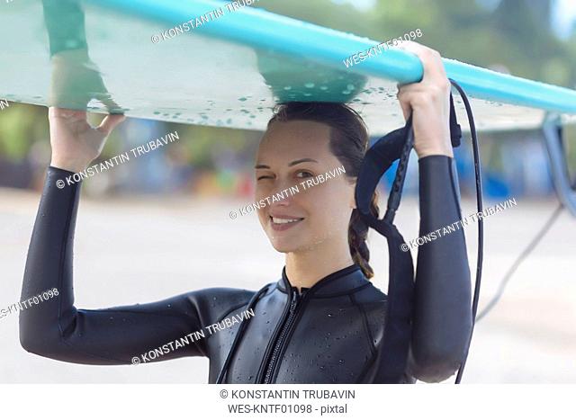 Indonesia, Bali, surfer with surfboard on the head