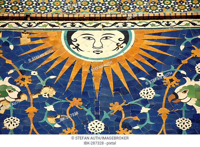 Face of the sun with rays as artful decorative maiolica on the portal of Nadir Divan-Begi Madrasah Bukhara Uzbekistan