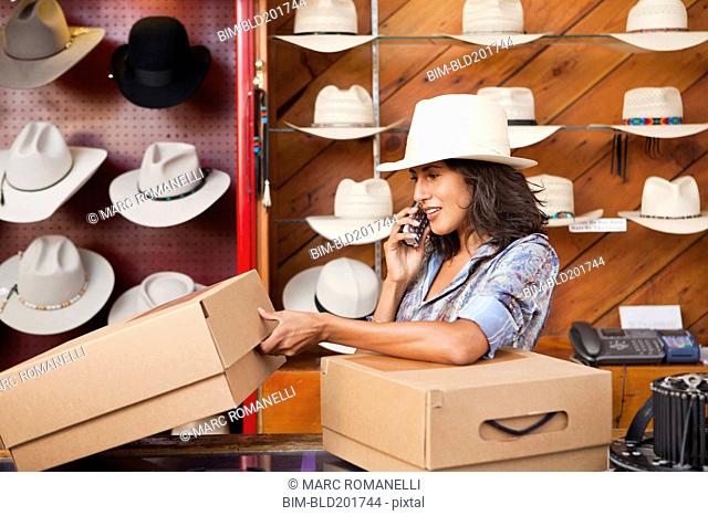 Ecuadorian woman talking on cell phone in hat store