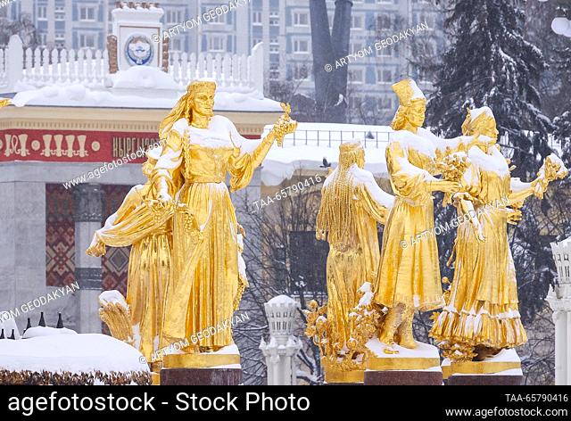 RUSSIA, MOSCOW - DECEMBER 15, 2023: Snow-covered gilded statues of the Friendship of the Peoples Fountain at the VDNKh exhibition centre and park