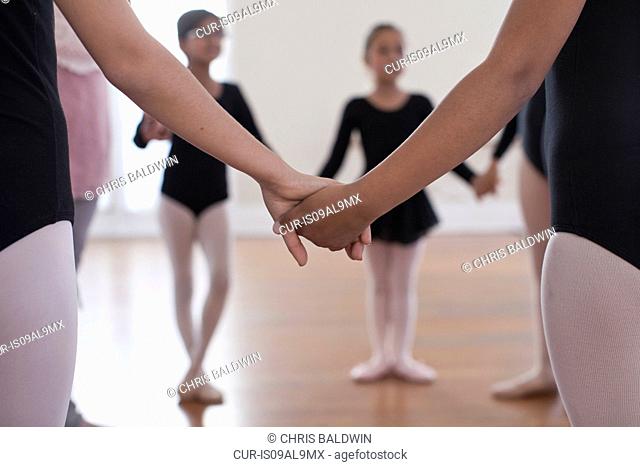 Rear view of a group of ballet school girls holding hands