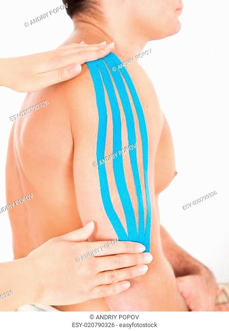 Person Applying Special Kinesio Tape On Man's Shoulder